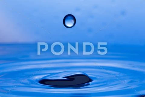 Drops, sprays, splashes of water on a colorful background Stock Photos