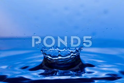 Drops, sprays, splashes of water on a colorful background Stock Photos