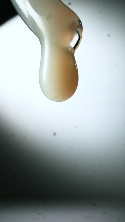 Drops of transparent, shiny, viscous liquid falling, viscous texture in the Stock Footage 340282876
