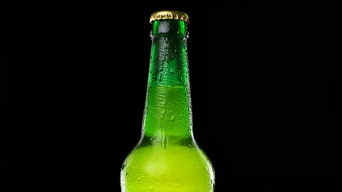 Drops trickle down the beer bottle. Cold and fresh beer bottle. black background Stock Footage 162031591