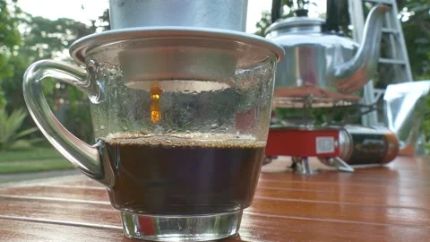 Drops of Vietnamese coffee from filter on the cup Stock Footage 132310116