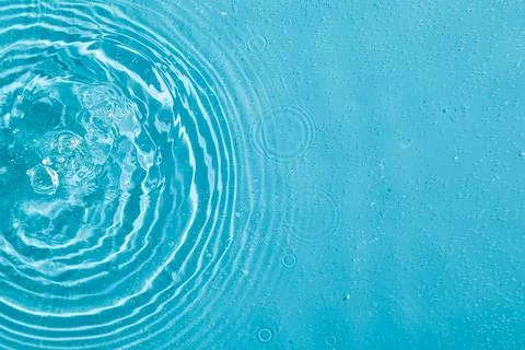 Drops on water with circles on a blue background Stockfoto's