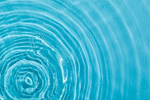 Drops on water with circles on a blue background Stock Photos
