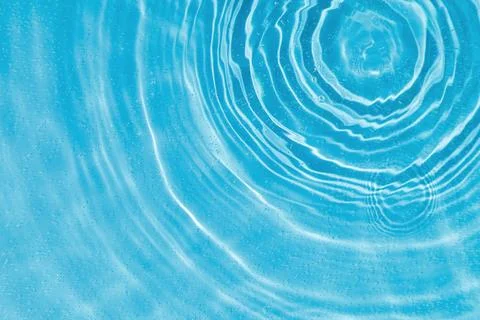 Drops on water with circles on a blue background Stock Photos