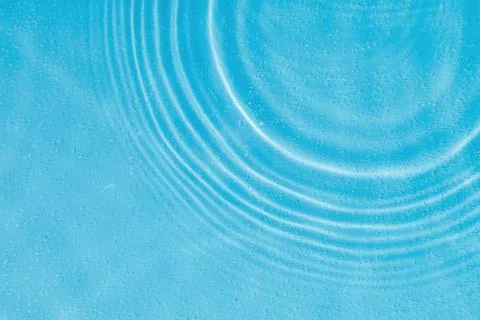 Drops on water with circles on a blue background Stock Photos