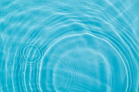 Drops on water with circles on a blue background Stock Photos