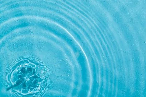 Drops on water with circles on a blue background Stock Photos