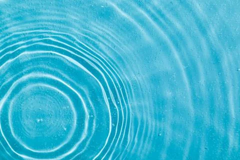 Drops on water with circles on a blue background Stock Photos