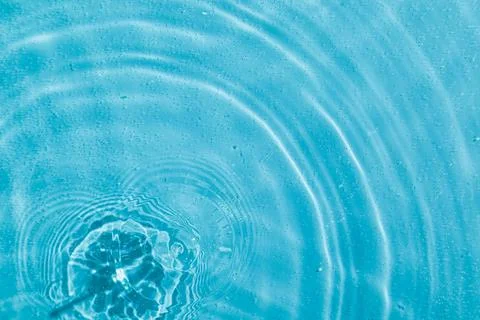 Drops on water with circles on a blue background Stock Photos
