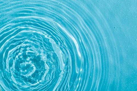Drops on water with circles on a blue background Stock Photos