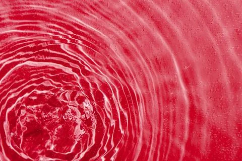 Drops on water with circles on a red background Stock Photos