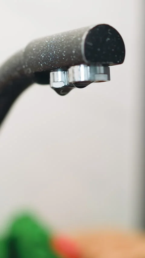 Drops of water drip from dark modern faucet into sink Stock Footage 307461540
