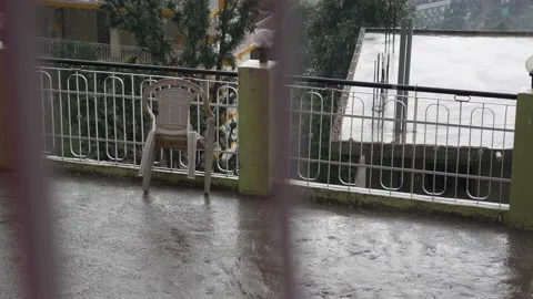 Drops of water dripping from the railing on the open terrace during heavy rain Stock Footage 225630689