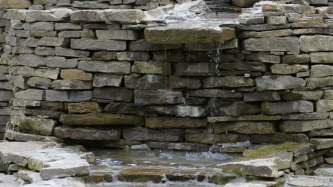 Drops of water fall from a brick artificial waterfall. Stock Footage 193987387
