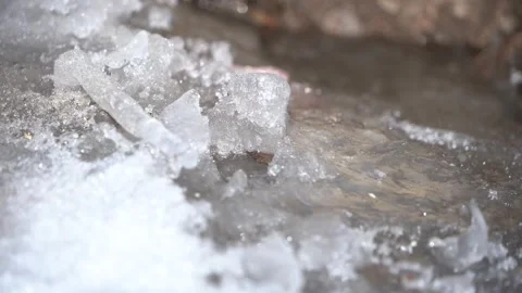 Drops of water fall on ice, spring in the mountains Stock Footage 147572363