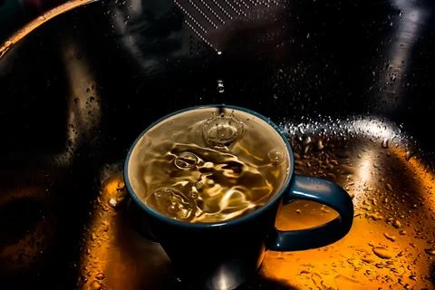 Drops of water falling into a cup Stock Photos