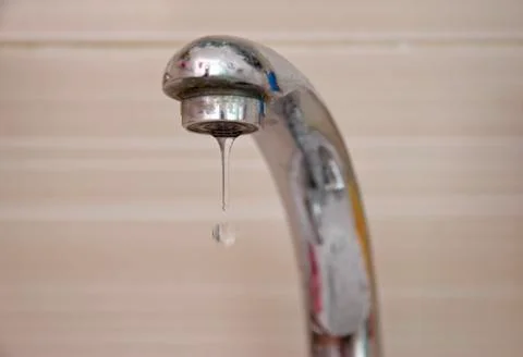 Drops of water falling down from the crane Stock Photos