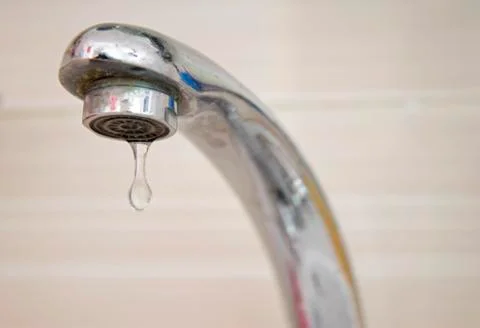 Drops of water falling down from the crane Stock Photos