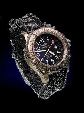 Drops of water falling on watch Stock Photos