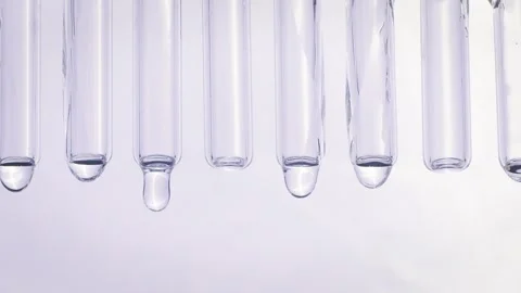 Drops of water flow down glass tubes Vídeo Stock 258322286