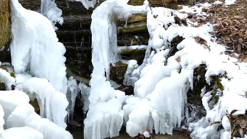 Drops of water flow down from ice at a waterfall 스톡 동영상 123573117