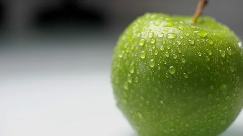 Drops of water flow down a juicy green apple. Food video Stock Footage 89368657