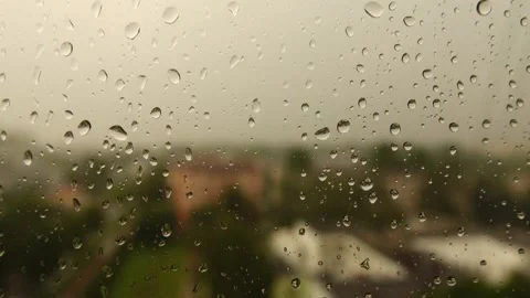 Drops of water flowing down glass during heavy rain. Cloudy summer weather. I Stock Footage 216029905