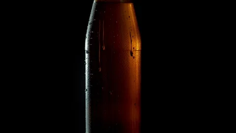 Drops of water flowing down on misted bottle Stock Footage 124292735