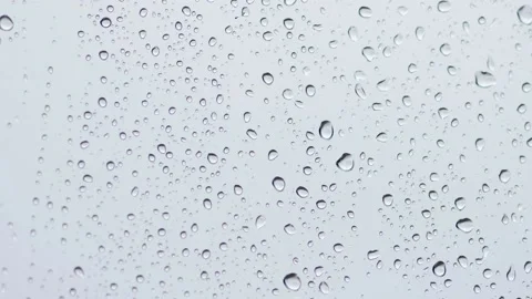 Drops of water on a light background. Rain drips down the glass during the day. Stock Footage 233031926