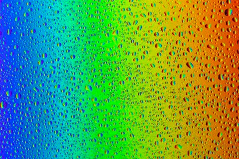 Drops of water on a rainbow background. Stock Photos