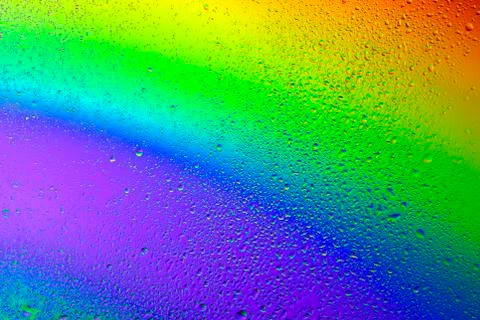 Drops of water on a rainbow background. Stock Photos