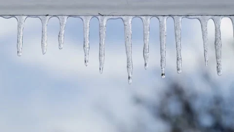 Drops of water run down the melting icicle close up view Stock Footage 142542820