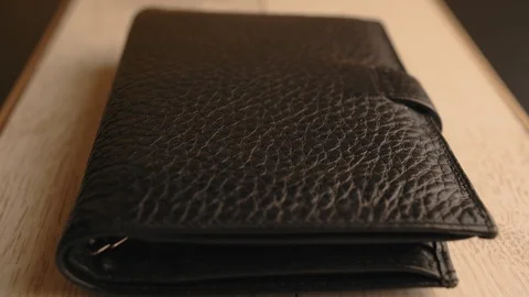 Drops of water splash onto a part of leather wallet. Waterproof and protection Stock Footage 126532590