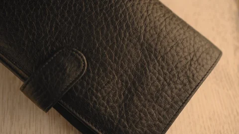 Drops of water splash onto a part of leather wallet. Waterproof and protection Stock Footage 126533864