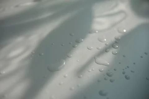 Drops of water on white surface with shadow Stock Photos