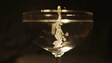 Drops of white matter fall into a glass beaker. Video stock 112666745