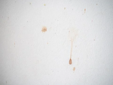 Drops on a white surface. Splashes of wine on the white wall. Dirty surface. Stock Photos