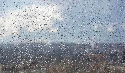 Drops on the window after the rain on the background of the city and the blue Stock Photos