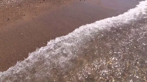 Drowned smartphone floats on bottom in waves of the sea surf sandy beach Stock Footage 79193977