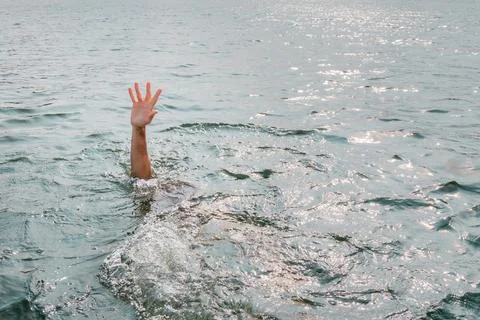 Drowning man, asking for help. Sticking hand out of water. Stock Photos