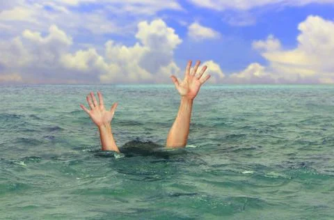 Drowning man hands stretched out to the surface for help at sea Stock Photos