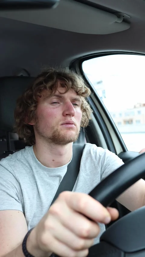 Drowsy driver slaps his cheeks to avoid falling asleep behind the wheel Stock Footage 342921935