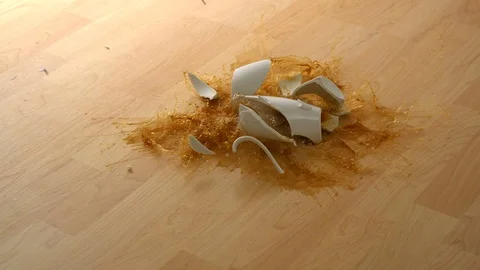 Drpping cup of coffee and breaking on wooden floor, Slow Motion Stock Footage 85654110