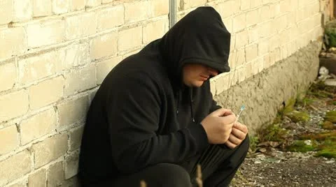 Drug addict man leaning against the wall Stock Footage