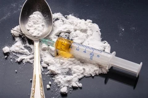 Drug syringe and cooked heroin Stock Photos