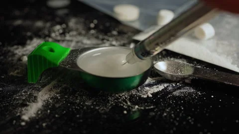 Drug user preparing liquid drugs in the syringe from cooker container used .. Stock Footage 323566962