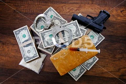 Drugs, Handcuffs, Gun, money and syringes on wooden table Stock Photos