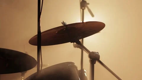 A drum cymbal in a drum kit on stage against a background of smoke and yellow Video stock 313891491