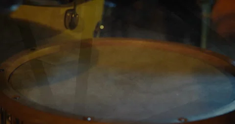 Drum head spinning slowly in 3D render, wooden rim glowing warmly, mallet Stock Footage 307676558