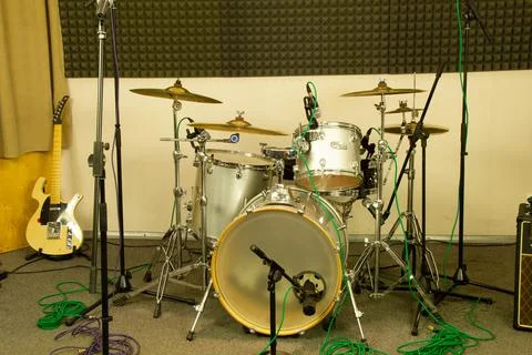 Drum kit and yellow electric guitar in a professional music studio. Musical Stock Photos